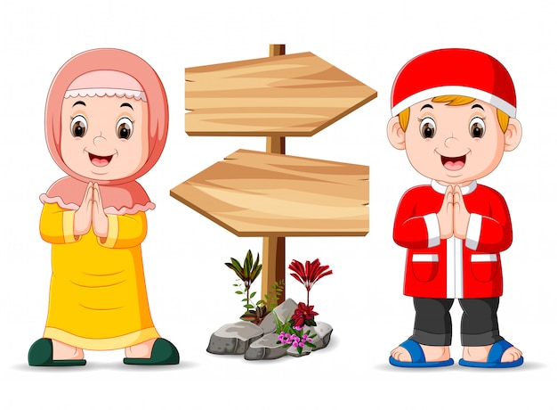 As duas crianças muçulmanas estão de pé perto da placa de madeira