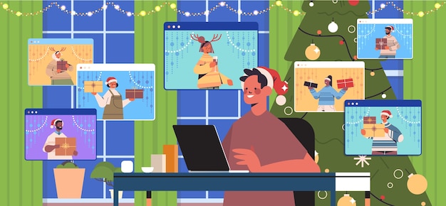 Cara com chapéu de papai noel usando laptop discutindo com amigos de raça mista no navegador da web