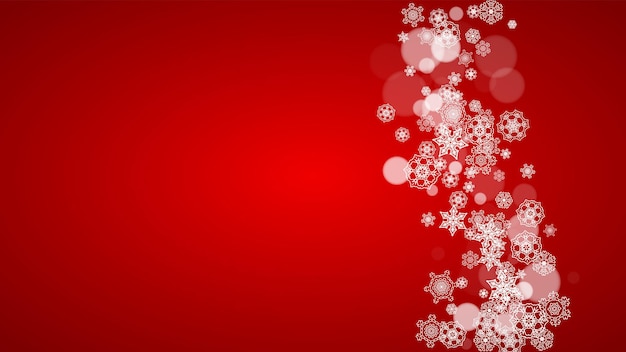 Flocos de neve de natal em fundo vermelho. cores do papai noel. quadro horizontal de flocos de neve de natal para banners de férias, cartões, vendas, ofertas especiais. queda de neve com bokeh para a celebração da festa