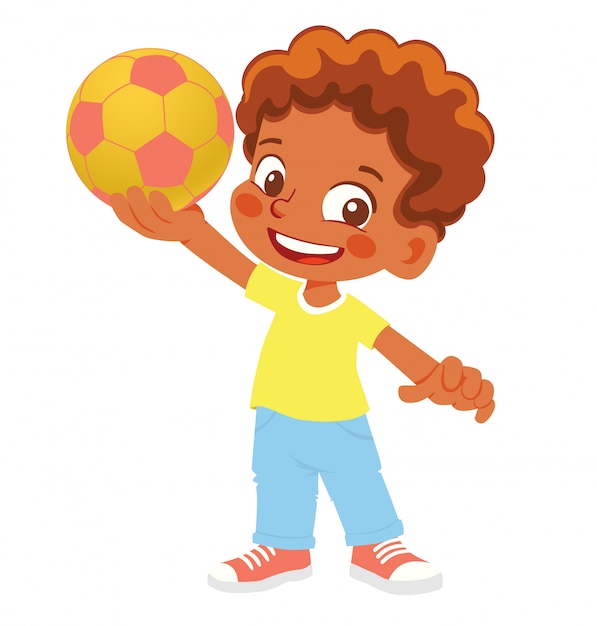 Menino afro-americano detém uma bola de futebol. Menino em pé com a bola