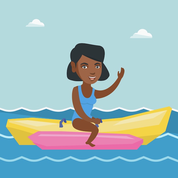 Mulher nova do african-american que monta um barco de banana.