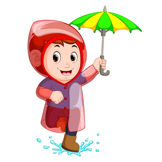 Rapaz pequeno que veste a capa de chuva e que guarda o guarda-chuva