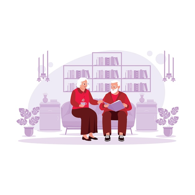 Um casal de idosos está sentado na sala tomando uma xícara de chá quente e olhando para uma lembrança