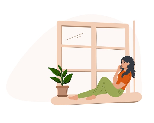 Uma jovem está sentada no parapeito da janela e falando ao telefone.