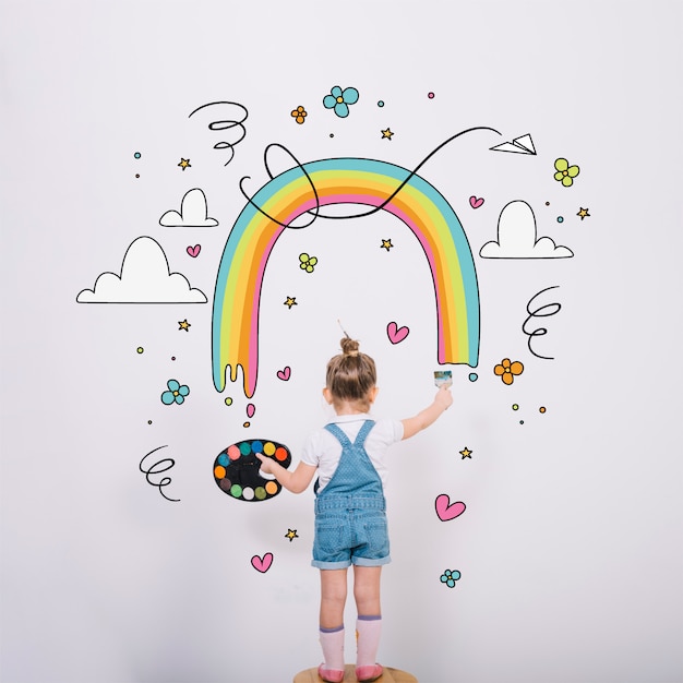 Bambina artistica che dipinge un arcobaleno meraviglioso