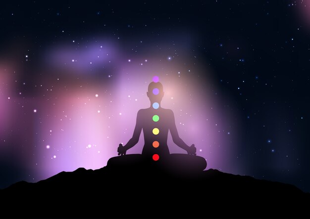 Siluetta di una donna con chakra nella posa di yoga contro il cielo notturno stellato