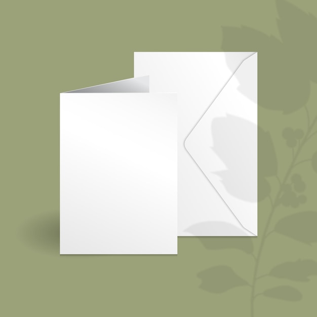 Carta verticale bianca e modello di busta con ramo di bacche di agrifoglio con foglie sovrapposte ombra.