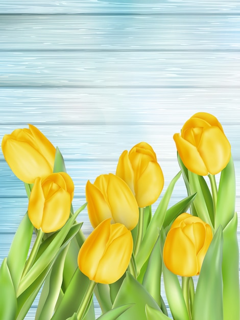 Fiori gialli dei tulipani sulle plance di legno.