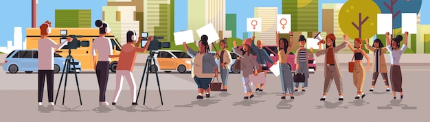 giornalisti che segnalano le ultime notizie dalle attiviste di protesta di strada che tengono cartelli dimostrazione femminista ragazza potere movimento donne empowerment concetto paesaggio urbano sfondo orizzontale integrale