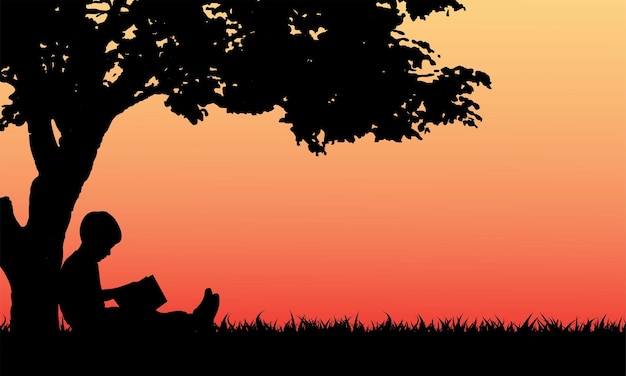 Libro di lettura del bambino sotto l'albero nel parco