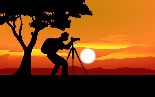 Paesaggio al tramonto con silhouette di fotografo