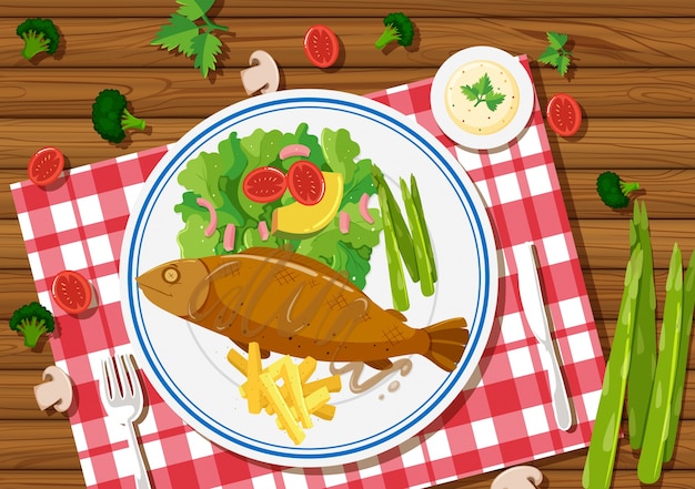 Pesce alla griglia e insalata sul piatto