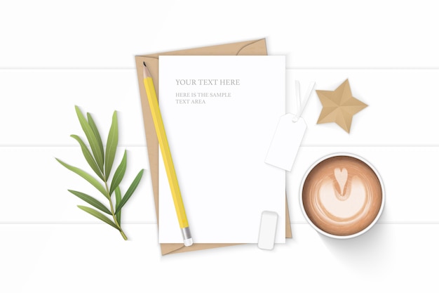 Piatto laici vista dall'alto elegante composizione bianca lettera carta kraft busta caffè matita stella tag mestiere foglia di dragoncello e gomma su sfondo di legno.