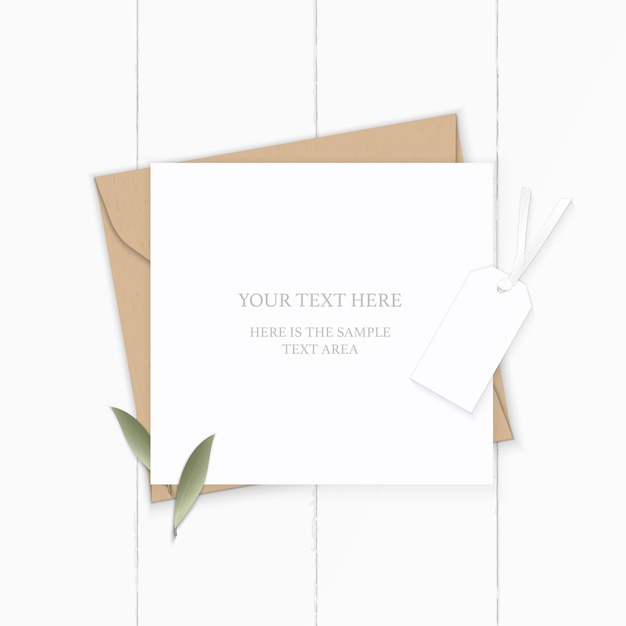 Piatto laici vista dall'alto elegante composizione bianca lettera kraft busta di carta natura foglia e tag su sfondo di legno.