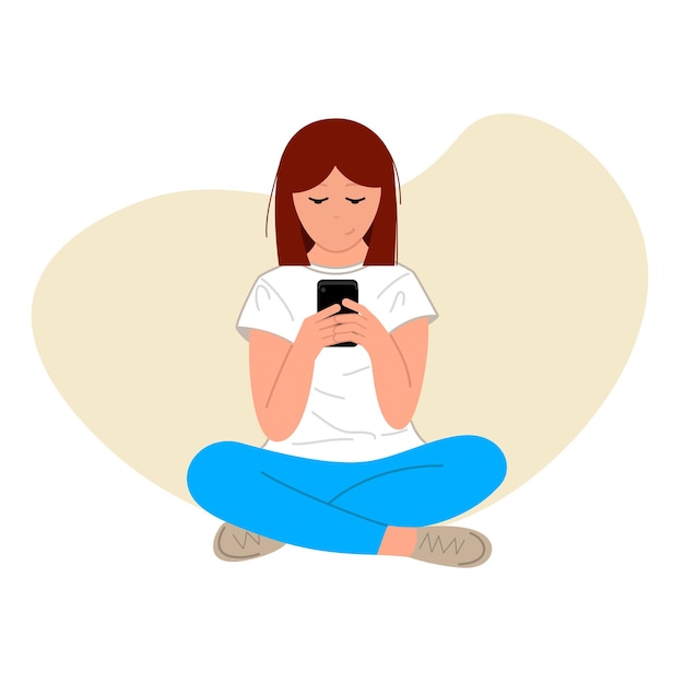 Ragazza dai capelli castani seduta con il telefono sulle mani