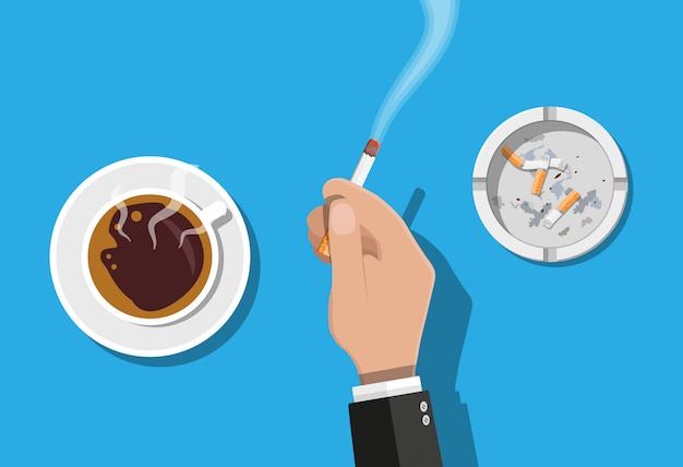 Tazza di caffè e portacenere pieni di sigarette fuma.