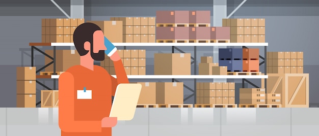 telefono afroamericano del caricatore dell'uomo che chiama l'interno del magazzino del pallet, orizzontale piano del ritratto di concetto internazionale di consegna della scatola dello scaffale