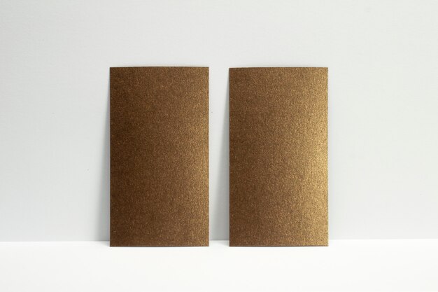 2 blanco bronzen visitekaartjes vergrendeld op witte muur, 3,5 x 2 inch formaat