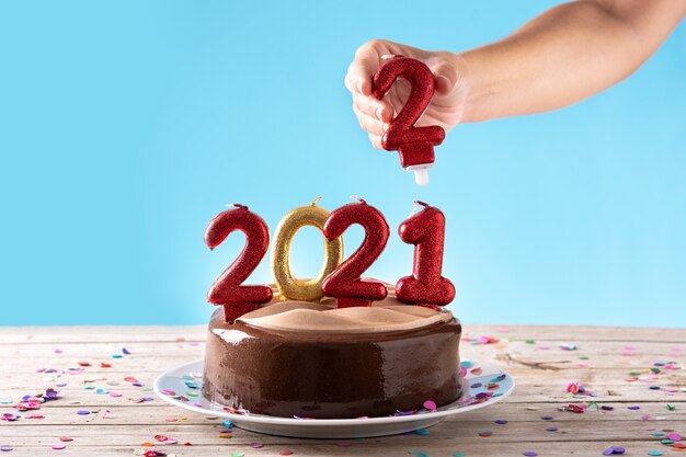 2022 cake en ornamenten op houten tafel en blauwe achtergrond