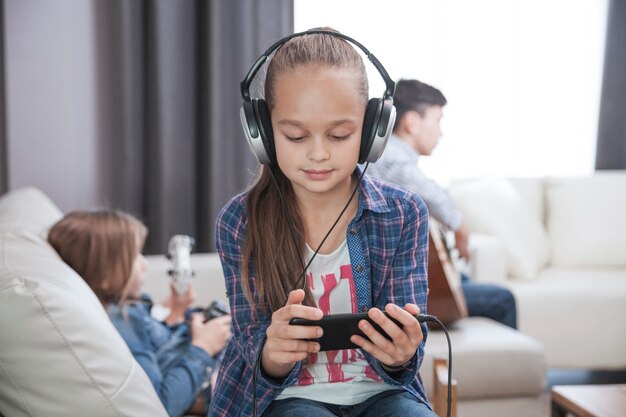 Aanbiddelijk meisje dat aan muziek luistert en tablet gebruikt