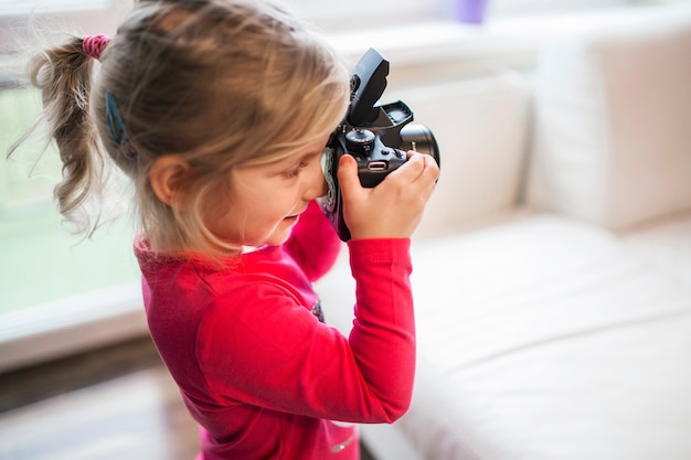 Gratis foto aanbiddelijk meisje met camera