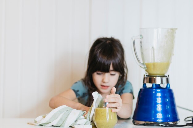 Aanbiddelijk meisje met glas op smoothie