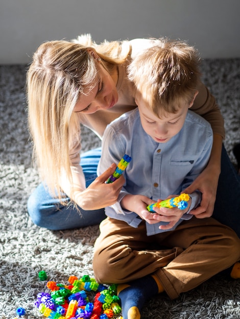 Aanbiddelijke jonge jongen die met speelgoed speelt