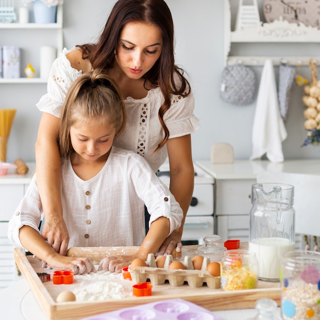 Aanbiddelijke moeder en dochter die koekjes voorbereiden