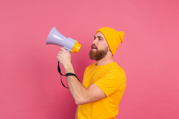 Aandacht! Europese man schreeuwen in megafoon op roze achtergrond