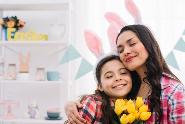 Gratis foto aangename vrouw en haar dochter omhelzen elkaar op paasdag