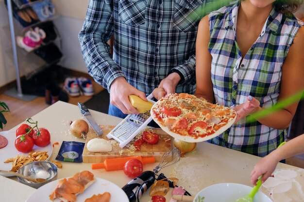 Aantrekkelijk paar brunette vrouw en een man in fleece shirt koken het eten in een huis familie keuken.