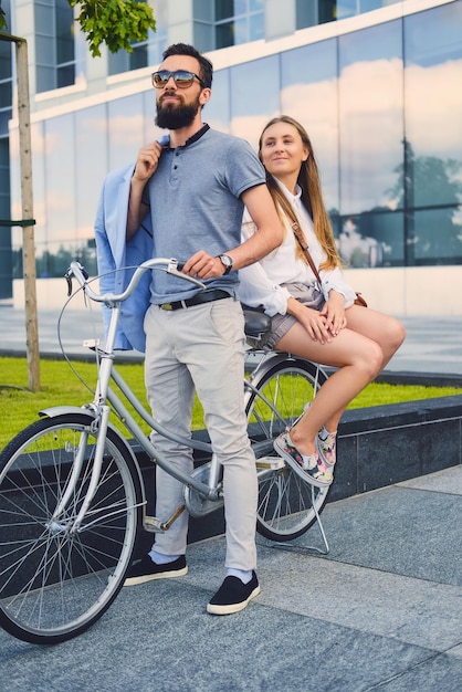 Aantrekkelijk stel op een date na een fietstocht in een stad.