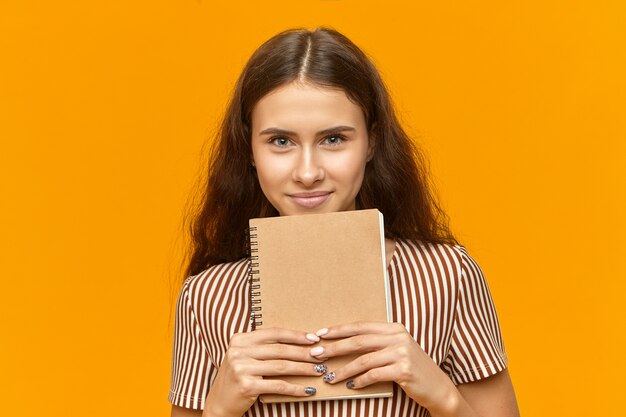 Aantrekkelijk wijfje Een student die met stijlvolle manicure camera met vrolijke glimlach bekijkt