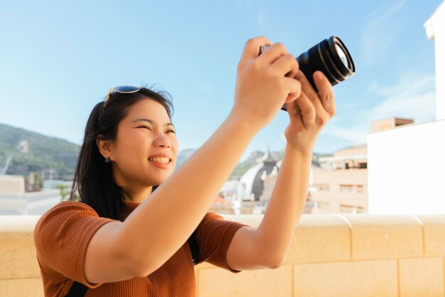 Aantrekkelijke Aziatische vrouwelijke reiziger toerisme hand gebruik camera sightseeing oude woningbouw architectuur in Cartagena, Spanje met geluk en vrolijk reisreis concept