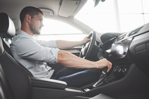 Aantrekkelijke bebaarde gelukkig man in goede auto.