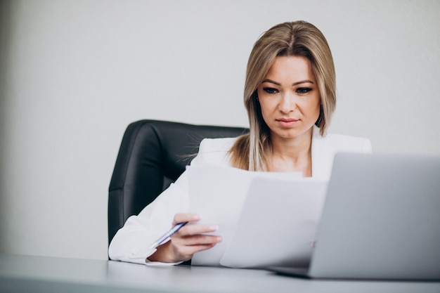 Aantrekkelijke bedrijfsvrouw die aan computer in bureau werkt