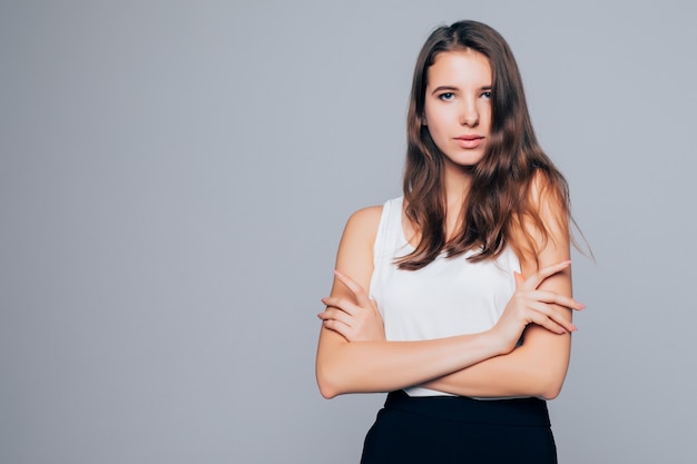 Aantrekkelijke brunette vrouw houdt haar armen in de buurt van haar gezicht geïsoleerd op een witte achtergrond