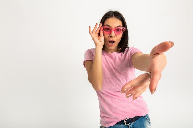 Aantrekkelijke gelukkig grappige emotionele vrouw in roze t-shirt geïsoleerde armen naar voren