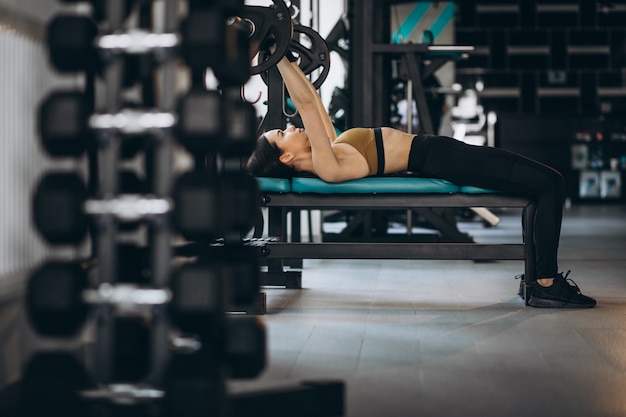 Gratis foto aantrekkelijke jonge vrouw die bij de gymnastiek uitoefent