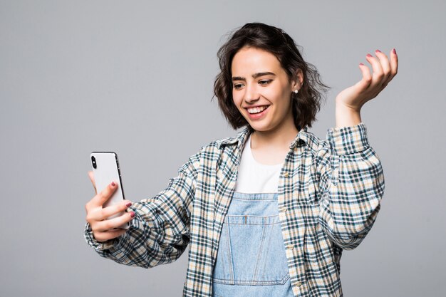 Aantrekkelijke jonge vrouw die selfie met telefoon neemt