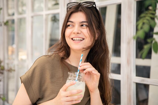 Aantrekkelijke jonge vrouw met een glas limonade op een warme zomerdag