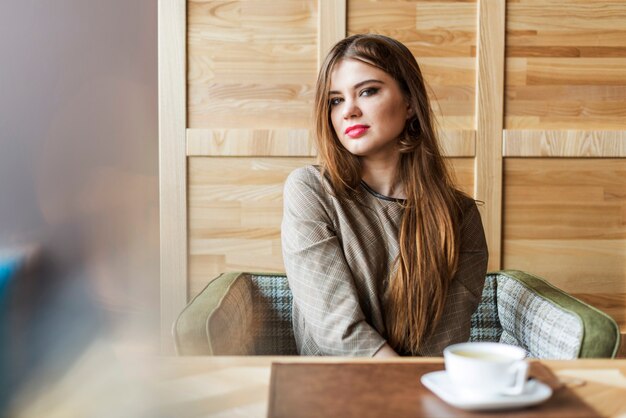 Aantrekkelijke jonge vrouw met lang haar in een coffeeshop