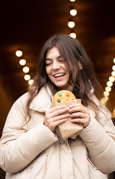 Aantrekkelijke jonge vrouw met peperkoek op een onscherpe achtergrond met bokeh