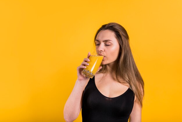 Aantrekkelijke jonge vrouw sap drinken uit glas