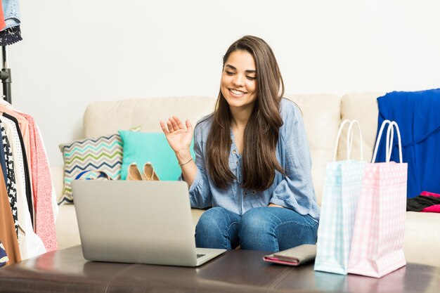 Aantrekkelijke jonge vrouwelijke modeblogger die tijdens een uitzending afscheid neemt van haar online publiek