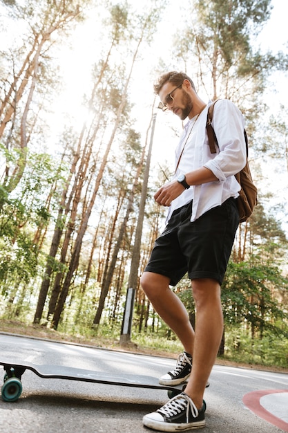 Aantrekkelijke man op skateboard buitenshuis