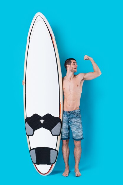 Aantrekkelijke surfer die een surfplank houdt