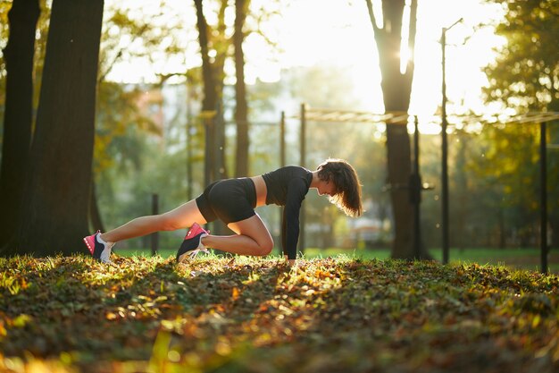 Aantrekkelijke vrouw die fysieke activiteit doet bij park