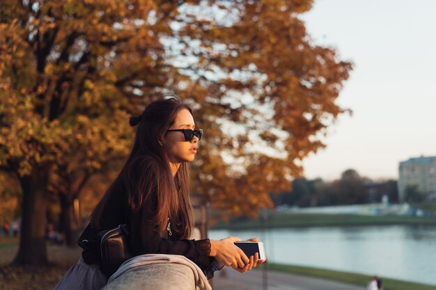 Aantrekkelijke vrouw die smartphone in openlucht in het park gebruiken