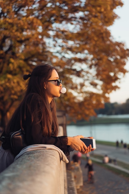 Aantrekkelijke vrouw die smartphone in openlucht in het park gebruiken